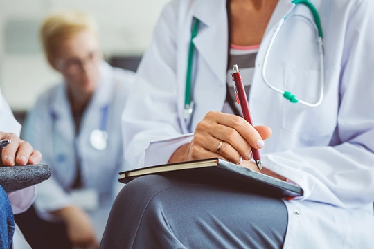 Seated Doctor In Lab Coat Taking Notes
