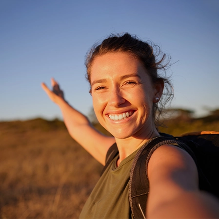 Woman Backpacking In Nature Smiling During Golden Hour
